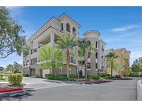 Elegant condo building featuring a modern design, lush landscaping, and private balconies at 9213 Las Manaitas Ave # 401, Las Vegas, NV 89144