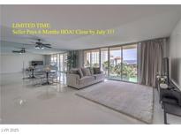 Bright living room featuring a sofa, glass doors to a balcony, and mirrored wall in a condo at 205 E Harmon Ave # 803, Las Vegas, NV 89169