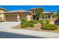 Charming single-story home showcasing a three-car garage, desert landscaping, and a tile roof at 3908 Specula Wing Dr, North Las Vegas, NV 89084