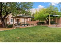 Inviting community park featuring picnic tables and lush green lawns, perfect for outdoor gatherings at 6045 Riverwalk Falls St # 102, North Las Vegas, NV 89031
