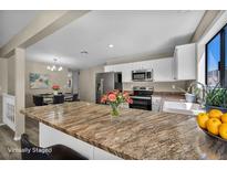 Bright kitchen featuring granite countertops, white cabinets, and stainless steel appliances at 6361 W Viking Rd, Las Vegas, NV 89103