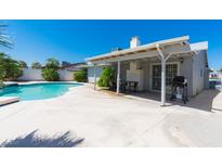 Outdoor space featuring a backyard swimming pool, patio area and covered outdoor kitchen and dining space at 6361 W Viking Rd, Las Vegas, NV 89103
