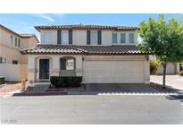 Two-story home with a two-car garage, desert landscaping, and a tile roof at 10673 Alondra Peak St, Las Vegas, NV 89183