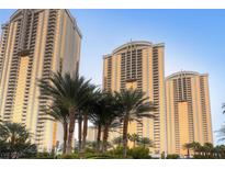 Stunning view of high-rise condo buildings with golden windows and tropical palm trees at 125 E Harmon Ave # 2215, Las Vegas, NV 89109
