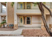 Inviting front entrance featuring a private balcony, tan stucco and decorative stone accents at 232 Morgyn Ln # 6, Boulder City, NV 89005