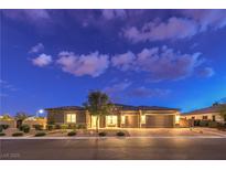 Charming single-story home featuring a three-car garage, desert landscaping, and inviting curb appeal at dusk at 8445 S Tenaya Way, Las Vegas, NV 89113