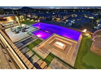 Stunning backyard oasis with a large pool, fire pit, and outdoor kitchen, perfect for entertaining under the stars at 10 Olympia Outlook Dr, Las Vegas, NV 89141