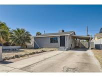 Charming single-story home featuring a spacious driveway and mature palm trees in a sunny, desert setting at 1645 Chestnut St, Henderson, NV 89011