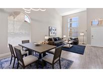 Bright living room with tall ceilings, large windows, and a dining area with seating for six at 191 Reed Ln, Henderson, NV 89074