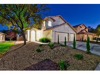 Charming stucco home featuring a three-car garage, desert landscaping, and a well-maintained front yard at 1933 Coralino Dr, Henderson, NV 89074