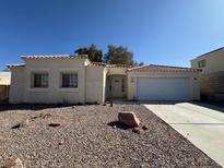 Charming single-story home featuring a two-car garage, tile roof, and low-maintenance desert landscaping at 3429 Back Country Dr, North Las Vegas, NV 89031