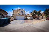 Two-story tan home with a two car garage, and a tile roof, under a sunny blue sky at 3871 Sir Bret Ct, Las Vegas, NV 89104