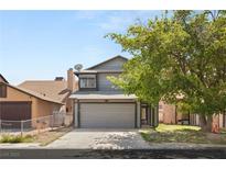Charming gray two-story home features a two-car garage and mature landscaping in a desirable neighborhood at 4197 Tolkien Ave, Las Vegas, NV 89115