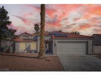 Charming single-story home featuring a well-manicured front yard and a two-car garage under a colorful sunset sky at 4212 Herblinda Ln, North Las Vegas, NV 89032