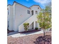 Inviting condo featuring well-maintained landscaping and a stucco facade with a staircase to the entrance at 698 S Racetrack Rd # 412, Henderson, NV 89015