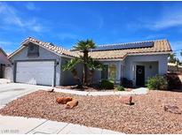 Charming single-story home featuring desert landscaping, a tile roof, and solar panels on a sunny day at 7417 Red Eagle St, Las Vegas, NV 89131