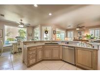 Well-lit kitchen featuring custom cabinets, granite countertops, stainless steel appliances, and a breakfast nook at 10290 Profeta Ct, Las Vegas, NV 89135