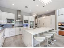 Modern kitchen featuring a large island with white marble counters and stainless steel appliances at 5 Clear Crossing Trl, Henderson, NV 89052