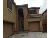 Tan two-story home featuring shutters, an attached two-car garage, and a concrete driveway at 7073 Seabirds Pl, North Las Vegas, NV 89084