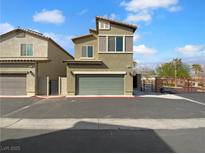 Two story tan home with a two car garage and desert landscaping at 7452 Sunray Point St, North Las Vegas, NV 89084