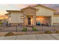 Charming single-story home with stone accents, a cozy front porch, and decorative iron fencing at 746 Purple Knoll Walk, Henderson, NV 89011