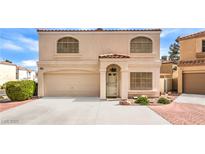 Charming two-story home featuring arched windows and a well-maintained front yard at 8861 Hampton Green Ave, Las Vegas, NV 89129