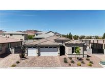 Beautiful single-story home with a three-car garage and a brick-paved driveway, and desert landscaping in the front yard at 1514 Washburn St, Boulder City, NV 89005