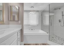 Bright bathroom featuring a tub and a separate glass-enclosed shower with modern fixtures and finishes at 42 Megan Dr, Henderson, NV 89074