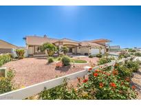 Charming single story home featuring a spacious front yard, three car garage and colorful rose bushes at 5231 E Chasemoor St, Pahrump, NV 89061