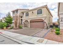Attractive two-story home featuring a tile roof, arched windows, and a two-car garage at 5409 Holding Ave, Las Vegas, NV 89139