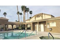 Community pool and hot tub with covered seating area and palm trees in the Sunhampton neighborhood at 7061 Roscoe Ave # 103, Las Vegas, NV 89129