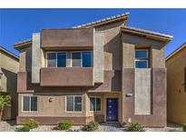 Modern two-story home featuring a blue front door, neutral color palette, and desert landscaping at 7477 Onyx Star St, North Las Vegas, NV 89084
