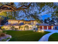 Elegant two-story home with a well-manicured lawn, fountain, and driveway leading to a three-car garage at 1 Quail Run Rd, Henderson, NV 89014