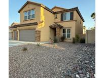 Charming two-story home featuring a two-car garage, neutral stucco, and desert landscaping at 1547 Harwood Ave, Henderson, NV 89012