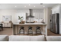 Bright, modern kitchen with stainless steel appliances, a large island, and seating for three at 1624 Preston Park Dr, Henderson, NV 89052