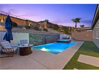 Inviting pool and spa with waterfall feature and lounge area, perfect for relaxing evenings at 18 Via Tiberina, Henderson, NV 89011