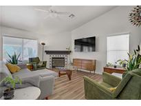 Bright living room features a decorative fireplace, contemporary furniture, and plenty of natural light at 1830 Ginger Blossom Ave, North Las Vegas, NV 89031