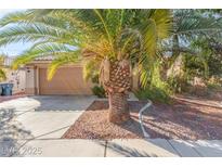 Home exterior featuring a two-car garage, mature palm tree and low maintenance rock landscaping at 2113 Diamond Brook Ct, Las Vegas, NV 89117
