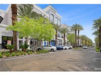 Attractive street view showcasing upscale buildings, lush palm trees, and a well-maintained parking area at 2260 Village Walk Dr # 1305, Henderson, NV 89052