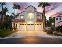 Striking two-story home featuring a three-car garage and desert landscaping with elegant palm trees at 2608 Sun Reef Rd, Las Vegas, NV 89128