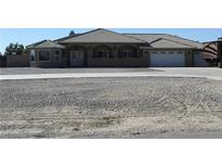 Sprawling single-story home with a large driveway, desert landscaping, and a tile roof at 3020 Peggy Ave, Pahrump, NV 89048