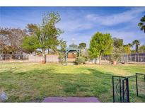 Spacious backyard featuring a charming gazebo, mature trees, and well-maintained lawn at 3100 Garehime St, Las Vegas, NV 89108