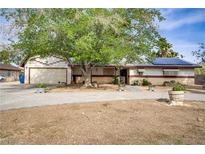 Charming single-story home featuring a large tree and a two car garage at 3100 Garehime St, Las Vegas, NV 89108