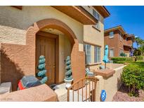 Charming two-story townhome featuring a front door with decorative spiral topiary and a cozy front patio at 3840 Belle Glade St # 104, Las Vegas, NV 89129