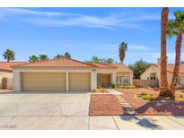 Charming single-story home with a two-car garage, desert landscaping, and a red tile roof at 4908 Wind Break Ln, North Las Vegas, NV 89031