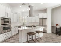 Modern kitchen boasts stainless steel appliances, a gas cooktop, and a granite countertop island with seating at 9228 Whitekirk Pl, Las Vegas, NV 89145