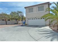 Two-story home with a large driveway and basketball hoop, great for outdoor fun at 9509 Arrowhead Falls Ct, Las Vegas, NV 89148