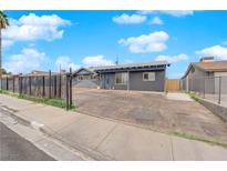 Charming single-story home with a spacious driveway and secure black metal fence at 1813 Constantine Ave, Las Vegas, NV 89101