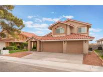 Charming two-story home with a three-car garage, red tile roof, and well-maintained landscaping at 2908 Reef Bay Ln, Las Vegas, NV 89128