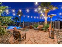 Inviting backyard patio with string lights, desert landscaping, pool, and comfortable seating, perfect for outdoor entertaining at 8113 Bay Colony St, Las Vegas, NV 89131